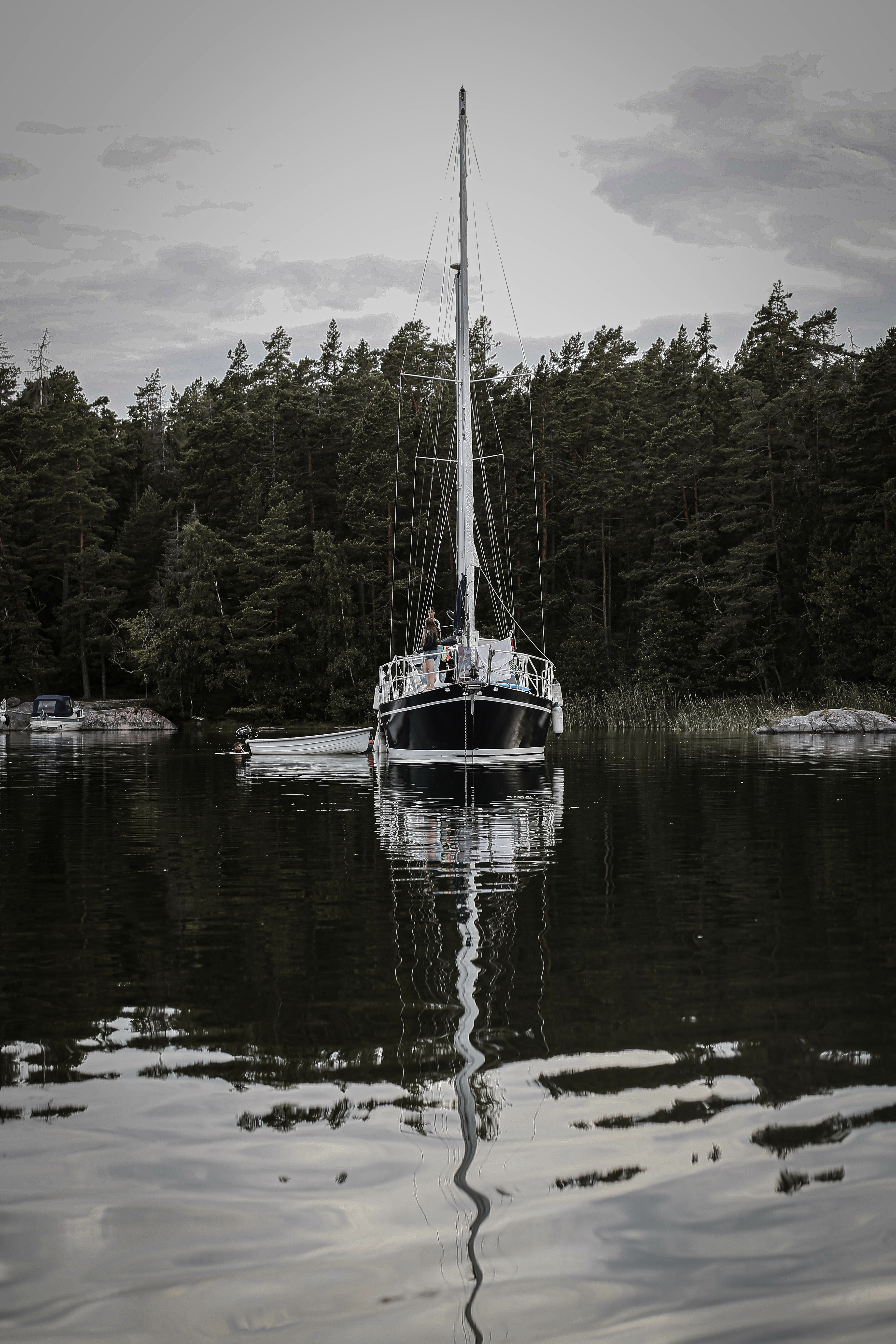 En segelbåt som ligger på ett spegelblankt hav i Stockholms skärgård 